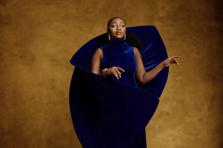Samara Joy in blue dress with golden backdrop